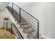 Modern staircase with sleek black railings and neutral carpeting leading to the upper level at 1286 Raleigh St, Denver, CO 80204
