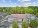 View of townhomes featuring well-maintained gray exteriors, brown roofing, and lush green landscaping at 1441 S Ulster St, Denver, CO 80231