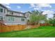Back exterior view featuring a well-kept lawn, wooden fence, and multi-level deck at 1441 S Ulster St, Denver, CO 80231