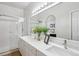 Bright bathroom featuring double sinks, a large mirror, and a glass-enclosed shower at 1441 S Ulster St, Denver, CO 80231