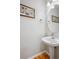 Elegant half bathroom features a modern pedestal sink and stylish framed wall art at 1441 S Ulster St, Denver, CO 80231