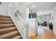 Inviting entryway featuring a carpeted staircase and view of the living room at 1441 S Ulster St, Denver, CO 80231