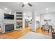 Open-concept living room with a fireplace, built-in shelves, and hardwood floors at 1441 S Ulster St, Denver, CO 80231