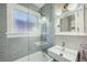 Modern bathroom with gray tile, glass enclosed shower over tub, and updated fixtures at 1640 Harrison St, Denver, CO 80206