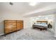 Spacious basement bedroom with carpet, large windows, a full bed, and wood dresser for ample storage space at 1640 Harrison St, Denver, CO 80206