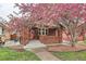 Charming brick home with a blossoming tree, offering curb appeal and a welcoming entrance at 1640 Harrison St, Denver, CO 80206