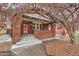 Charming red brick home with blossoming tree and inviting front porch at 1640 Harrison St, Denver, CO 80206