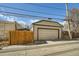 Detached two-car garage with tan siding and a well-maintained concrete driveway, and wood fence at 1640 Harrison St, Denver, CO 80206