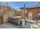 Backyard with a relaxing hot tub beside a brick house with outdoor heating system, enclosed by a fence at 1640 Harrison St, Denver, CO 80206
