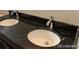 Modern bathroom with black granite countertops and double sinks at 15305 W 93Rd Ave, Arvada, CO 80007