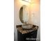 Close-up of an oval mirror and granite countertop with vessel sink in a modern bathroom at 15305 W 93Rd Ave, Arvada, CO 80007