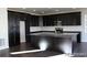 Modern kitchen features dark cabinets, a large island, and stainless steel appliances at 15305 W 93Rd Ave, Arvada, CO 80007