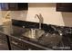 Close-up showcasing the wet bar's elegant granite countertop and modern stainless steel sink at 15305 W 93Rd Ave, Arvada, CO 80007