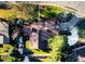 An aerial view of a home showcasing its roof, well-manicured lawn, and surrounding trees in a residential neighborhood at 2130 Tabor Dr, Lakewood, CO 80215