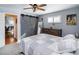 Cozy bedroom with a rustic wood dresser, full length mirror, and unique gray sliding barn door at 2130 Tabor Dr, Lakewood, CO 80215