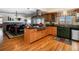 Kitchen island with cooktop, wooden cabinets, and seamless access to the dining area at 2130 Tabor Dr, Lakewood, CO 80215