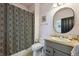 A bathroom with a toilet, patterned shower curtain, and oval mirror at 6985 Fallon Cir, Castle Rock, CO 80104