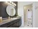 Bathroom showcasing a black vanity, round mirror, and white tile flooring at 6985 Fallon Cir, Castle Rock, CO 80104