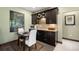 Charming bar area with rich wood cabinetry, granite countertops, and cozy dining space at 10243 Spring Green Dr, Englewood, CO 80112