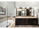 Bathroom boasts dual sinks, dark wood cabinets, a soaking tub, and a glass enclosed shower at 10243 Spring Green Dr, Englewood, CO 80112