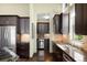Modern kitchen featuring stainless steel appliances, dark wood cabinets, and stone countertops at 10243 Spring Green Dr, Englewood, CO 80112