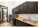 Laundry room with modern washer/dryer, granite countertops, and dark wood cabinetry at 10243 Spring Green Dr, Englewood, CO 80112