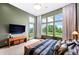 Bright main bedroom featuring a large window with views, a flatscreen TV, and sleek contemporary furnishings at 10243 Spring Green Dr, Englewood, CO 80112