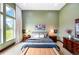 Spacious main bedroom with a large window, neutral decor, and a comfortable bed with stylish linens at 10243 Spring Green Dr, Englewood, CO 80112