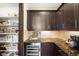 Walk-in pantry with custom shelving and wine refrigerator at 10243 Spring Green Dr, Englewood, CO 80112