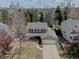 Aerial view of home with green lawn and trees, garage, and covered front porch at 6719 E Costilla Cir, Centennial, CO 80112