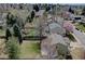 An aerial view of a fenced backyard with a trampoline surrounded by mature trees and a lush green lawn at 6719 E Costilla Cir, Centennial, CO 80112