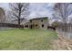 View of backyard and home exterior, featuring a well-maintained lawn and wooden fence at 6719 E Costilla Cir, Centennial, CO 80112