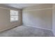 Empty carpeted bedroom showcasing neutral walls, white trim, and a large window at 6719 E Costilla Cir, Centennial, CO 80112