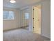 Carpeted bedroom featuring a mirrored closet, window, and doorway to a bathroom at 6719 E Costilla Cir, Centennial, CO 80112