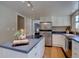Bright kitchen features stainless steel appliances, white cabinetry and a modern cooktop island at 6719 E Costilla Cir, Centennial, CO 80112