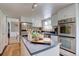 Kitchen boasts stainless appliances, white cabinets, island cooktop, and a view from the window over the sink at 6719 E Costilla Cir, Centennial, CO 80112