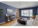Living room featuring hardwood flooring, blue walls and large window at 6719 E Costilla Cir, Centennial, CO 80112