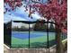 A colorful tree hangs over a tennis court in a fenced area with a clean net and a green and blue surface at 6719 E Costilla Cir, Centennial, CO 80112