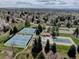 Aerial view of well-maintained community tennis courts next to a clubhouse and covered swimming pool surrounded by trees at 6719 E Costilla Cir, Centennial, CO 80112