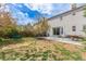 Lush backyard with patio seating, grassy area, and mature trees offers a private retreat at 4808 S Ward Way, Morrison, CO 80465
