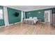 Bright main bedroom features wood floors, green walls, and ambient sconce lighting at 4808 S Ward Way, Morrison, CO 80465