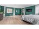 Spacious main bedroom with green walls, wood floors, and natural light at 4808 S Ward Way, Morrison, CO 80465