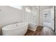 Bathroom features a freestanding tub, glass-enclosed shower, and wood-look tile flooring at 1281 Loraine N Cir, Lafayette, CO 80026