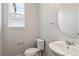 A half bathroom includes modern fixtures such as a sink, oval mirror, and efficient toilet at 1281 Loraine N Cir, Lafayette, CO 80026