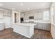 Bright kitchen with white cabinets, stainless steel appliances, a center island, and wood flooring at 1281 Loraine N Cir, Lafayette, CO 80026