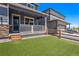Home exterior featuring a covered porch, small lawn, and fenced yard at 11933 Norfolk Ct, Commerce City, CO 80022