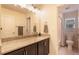 Bright bathroom with a single vanity, granite countertop, and shower with white tile at 11933 Norfolk Ct, Commerce City, CO 80022