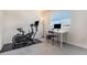 Carpeted room featuring exercise equipment, desk, and window for natural light at 11933 Norfolk Ct, Commerce City, CO 80022