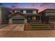 Two-story blue home featuring a front porch, fenced front yard and attached two-car garage at 11933 Norfolk Ct, Commerce City, CO 80022