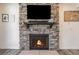 Cozy living room fireplace with a stone surround, wooden mantle, and hearth at 11933 Norfolk Ct, Commerce City, CO 80022